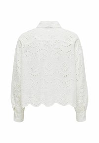 Blouse blanche courte avec un design en œillets brodés et un ourlet festonné. Les manches longues et les poignets boutonnés mettent en valeur le tissu texturé.