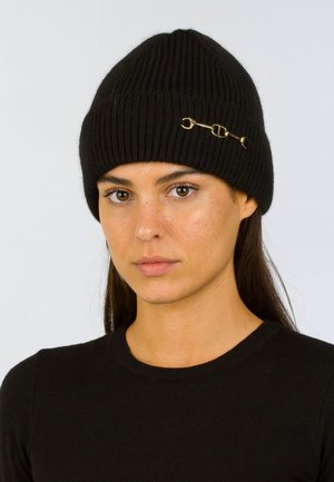 Czarna dzianinowa czapka beanie o prążkowanej fakturze oraz złotym akcentem w postaci zapięcia. Prosty, dopasowany kształt.