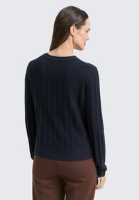 Navy-blau gestreifter Pullover mit Rundhalsausschnitt und langen Ärmeln, aus weichem Strickmaterial gefertigt, mit enger Silhouette und strukturiertem Finish.