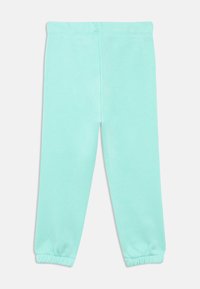 Τιρκουάζ βαμβακερό κολάν με λεία υφή, ελαστική μέση και στενά μανσέτες στους αστραγάλους. Χωρίς εμφανή σχέδια ή επιπλέον λεπτομέρειες.