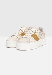 Sneakers platform bianchi con tomaia in tessuto beige a motivo, caratterizzati da un accento marrone e lacci bianchi. Punta arrotondata e finitura liscia.