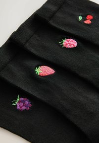 Svarta strumpor med broderade fruktdesign: körsbär, jordgubbar och vindruvor. Varje design har livfulla färger och detaljerad sömnad.
