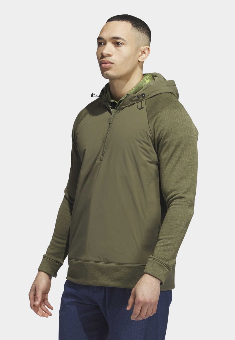 Khaki zielony hoodie z półzamkiem, teksturowanymi rękawami oraz regulowanymi zapięciami przy szyi. Czyste linie i dopasowany krój.