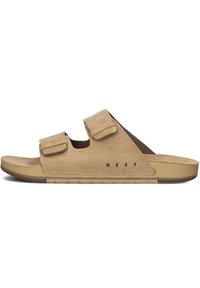 Sandales en daim de couleur beige clair avec deux sangles velcro ajustables. Présentent un semelle intérieure anatomique et une semelle en caoutchouc pour l'adhérence. Logo imprimé sur le côté.