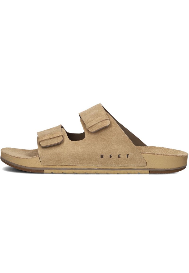 Sandales en daim de couleur beige clair avec deux sangles velcro ajustables. Présentent un semelle intérieure anatomique et une semelle en caoutchouc pour l'adhérence. Logo imprimé sur le côté.