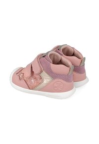 Zapatos de niño pequeños en rosa y dorado con lentejuelas texturizadas y detalles de ante, que cuentan con una correa de Velcro y una suela blanca flexible.