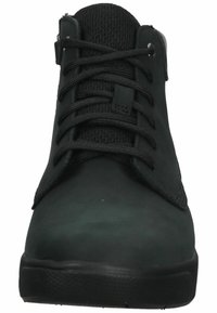 Ciemnozielone wysokie buty, wykonane z gładkiego materiału z siateczkowym językiem. Posiadają czarne sznurówki oraz gumową podeszwę z teksturowanym wzorem zapewniającym przyczepność.