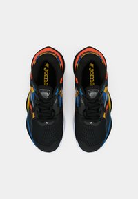 Black athletic shoes with multicolored accents in orange, blue, and yellow. Mesh upper with textured details and white soles.