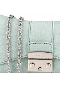 Bolso de mano de tela azul claro con acabado metalizado, que cuenta con una cadena plateada y un cierre de presión plateado, grabado con "Furla."