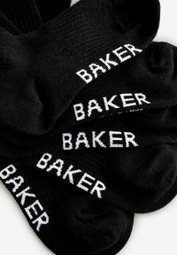 Mustad mustad sokid, millel on valge "BAKER" tekst, kergelt soonilised ja madala lõikega, asetatud kihiliselt.