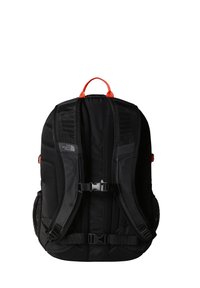 Mochila preta com painéis em malha, alças ajustáveis e detalhes laranja. Possui fecho com fivela e bolsos laterais para armazenamento.