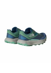 Zapatillas de senderismo ligeras en malla azul y verde, con un acabado texturizado, cuellos acolchados y una suela de goma verde menta gruesa para tracción.