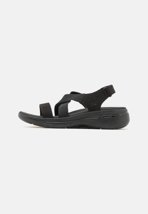 Black sport sandals with adjustable straps, cushioned footbed, and textured sole. Lightweight design for comfort and support.