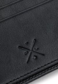 Czarny skórzany portfel z teksturowaną powierzchnią, szytymi krawędziami oraz wytłoczonym geometrycznym logo z minimalnym zdobieniem.