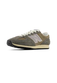 Ανδρικό αθλητικό παπούτσι τρεξίματος σε ελιά πράσινο σουέτ και δίχτυ, με ουδέτερη κρεμ σόλα και εμφανές λογότυπο 'N' σε ανοιχτό γκρι.