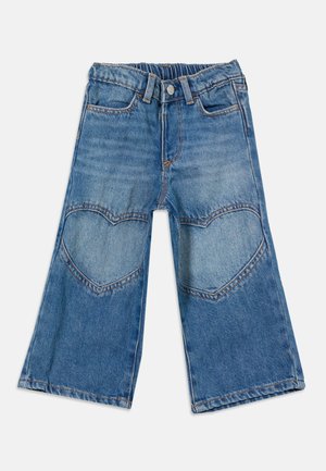 Jean large bleu pour enfants avec ceinture élastique et patchs en forme de cœur aux genoux, présenté sur fond blanc.