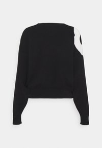 Pull noir à manches longues avec un motif circulaire blanc sur l'épaule gauche supérieure, vu de dos sur un fond blanc.