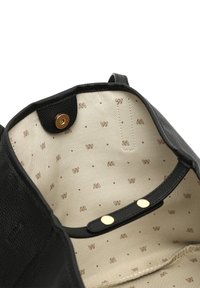 Interiér čiernej koženej kabelky s béžovou podšívkou, zdobený hnedými logovými vzormi. Obsahuje dva zlaté cvokové uzávery. Hladký povrch.