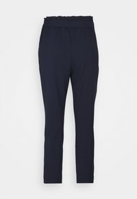 Pantalon bleu marine fuselé avec taille élastique ornée d'un fini à volants ; texture lisse, tissu léger et sans poches.