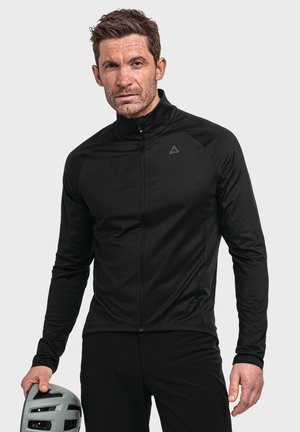 Black long-sleeve cycling jacket with a high collar and zip front. Features a textured fabric and a logo on the chest. Foreground includes a cycling helmet.