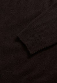 Dunkelbrauner Pullover aus weichem, strukturiertem Stoff mit gerippten Bündchen, der ein glattes und minimalistisches Design präsentiert.