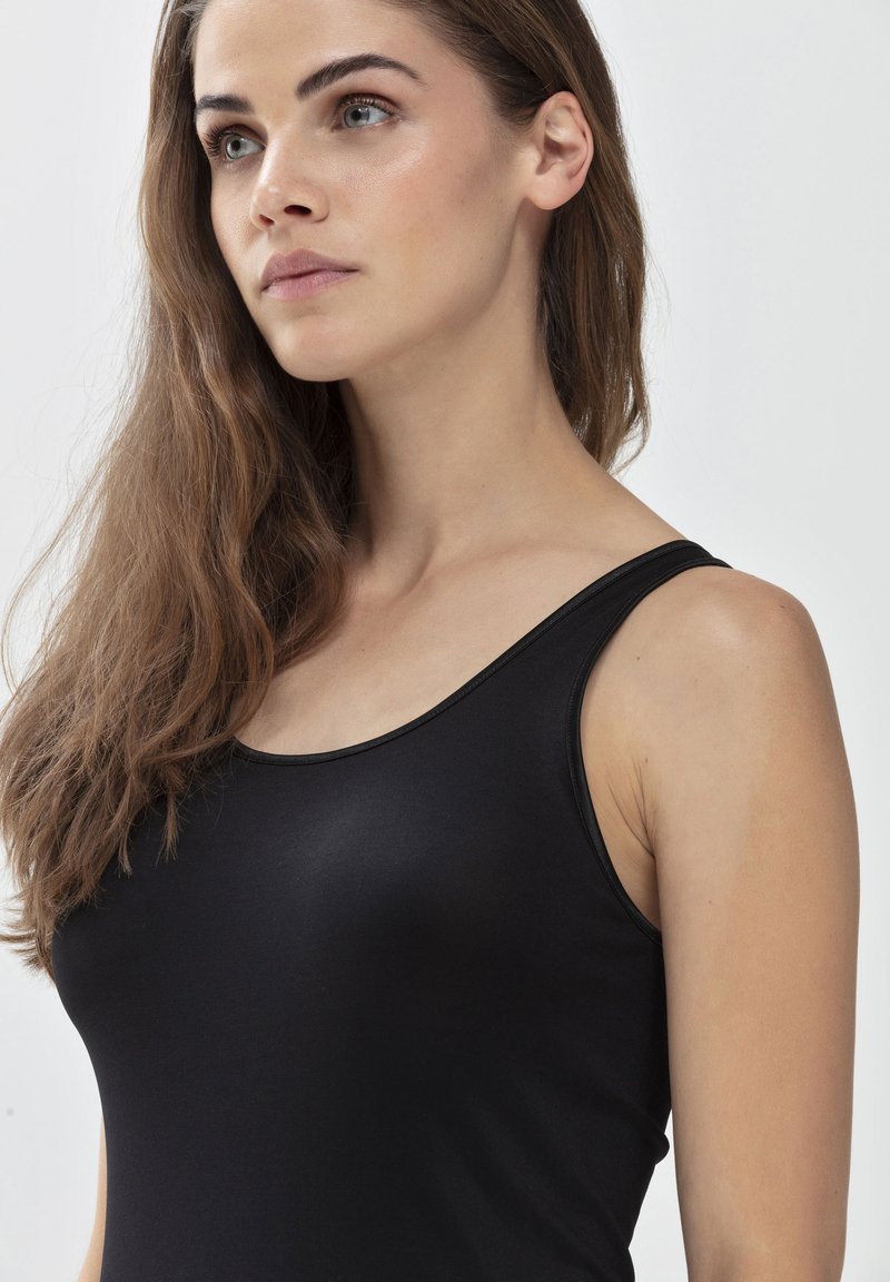 Czarny top na ramiączkach z cienkimi paskami, wykonany z gładkiego, elastycznego materiału. Posiada okrągły dekolt oraz dopasowany krój.