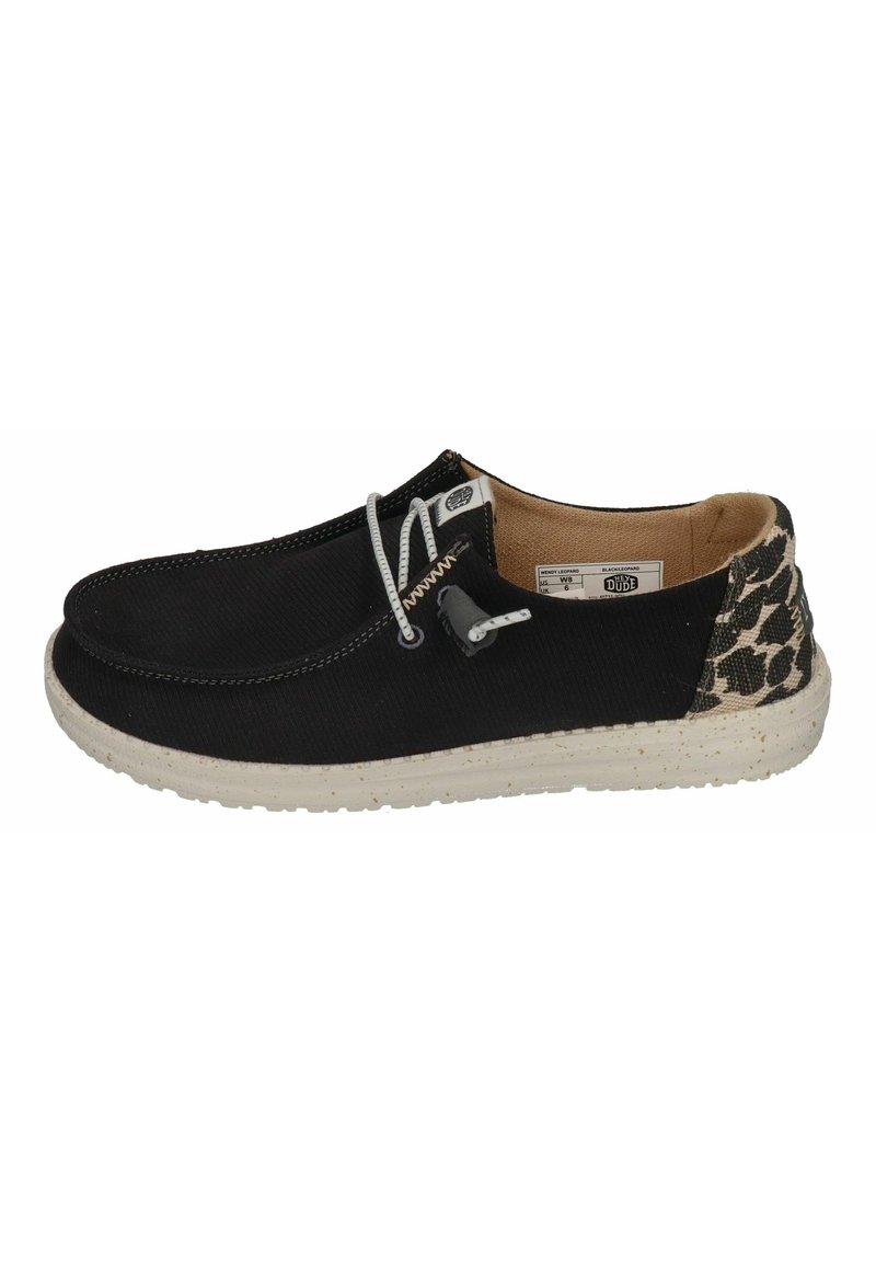 Black canvas slip-on shoe with white laces, a speckled rubber sole, and a leopard print accent at the heel.