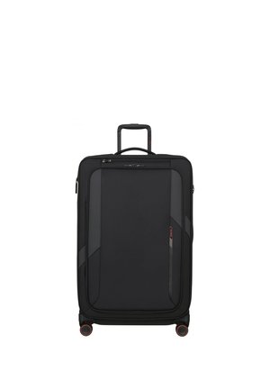 Black upright soft-shell suitcase with four spinner wheels, extended telescopic handle, front zip pocket, and top carry handle.