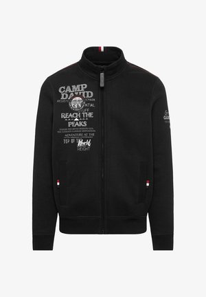 Schwarze Zip-Jacke mit hohem Kragen. Verfügt über aufgedruckten Text und ein Abzeichen auf der Vorderseite, kontrastierender Naht und gerippten Bündchen.