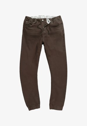 Braune, schlanke Hose mit elastischem Bund, Kordelzug, Knopfverschluss und vorderen Taschen, flach auf weißem Hintergrund gelegt.