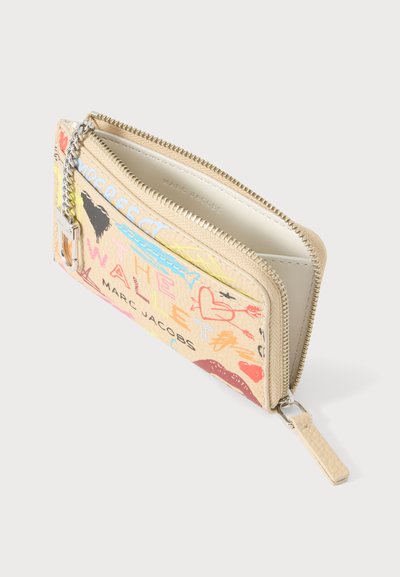 Μπεζ πορτοφόλι Marc Jacobs με φερμουάρ γύρω-γύρω, πολύχρωμο κείμενο σε στυλ graffiti και καρδιά, με κρεμαστό μπρελόκ αλυσίδας, μερικώς ανοιχτό.