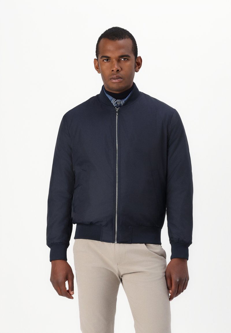 Marine bomberjakke med glidelås foran, ribbestrikkede mansjetter og nederkant, lett materiale, med rund krage og sidelommer.