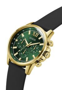 Orologio cronografo color oro con quadrante verde, cinturino in silicone nero, tre sottoquadranti e indici delle ore dorati. Caratterizzato da un prominente "XII".