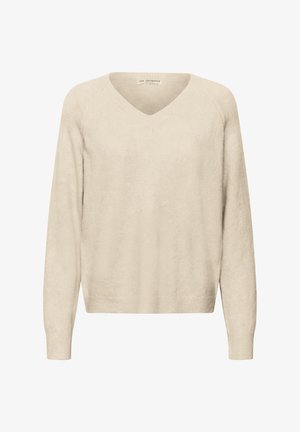 Bēša adīts džemperis ar V veida izgriezumu, garām raglāna piedurknēm un ribainiem apročiem un apakšmali. Mīksta tekstūra ar brīvu pieguļumu.