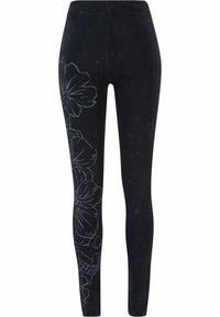 Sorte leggings med teksturert overflate, med et hvitt blomstermønster langs venstre bein. Elastisk midjebånd, tettsittende design.