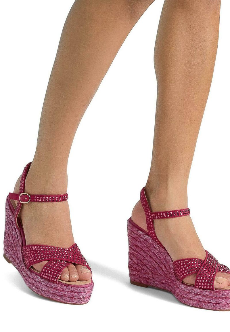 Sandali con zeppa rosa, con una piattaforma tessuta e strutturata e un cinturino decorato con strass. Design a punta aperta con cinturino alla caviglia regolabile.