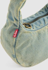 Lichtblauwe denim schoudertas van Levi's met een messingrits en een rode Levi's merkmunt aan de zijnaad.