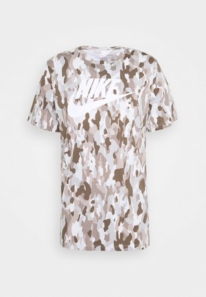 Koszulka Nike z krótkim rękawem w beżowy, biały i brązowy wzór moro oraz dużym białym logo Nike na wysokości klatki piersiowej.