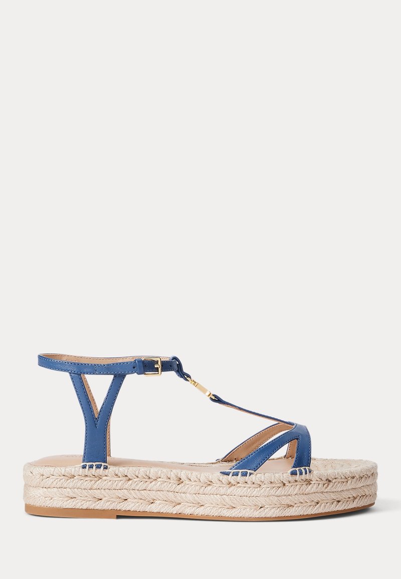 Sandale en cuir bleu avec une plateforme de style espadrille, dotée d'une semelle en jute tissée, d'une sangle de cheville réglable et d'un design de orteil entrecroisé.