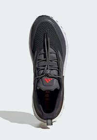 Black and gray athletic shoe with a textured mesh upper, elastic laces, and red "ULTRABOOST" branding on the insole. White rubber outsole.