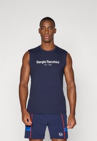 Marineblå ærmeløs skjorte med hvid "Sergio Tacchini EST. 1966" logo. Bæres med matchende marineblå shorts, der har rød og blå striber samt logo.