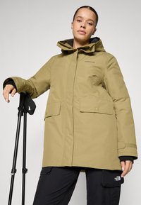 Olivgrön vattentät parka med huva, utrustad med två frampocket, justerbara ärmar och dragkedja fram.