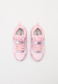 Baskets de sport roses avec des accents argentés métalliques, tissu texturé, fermeture à lacets et tirant au talon arrière. Semelle épaisse et rembourrée pour un bon soutien.