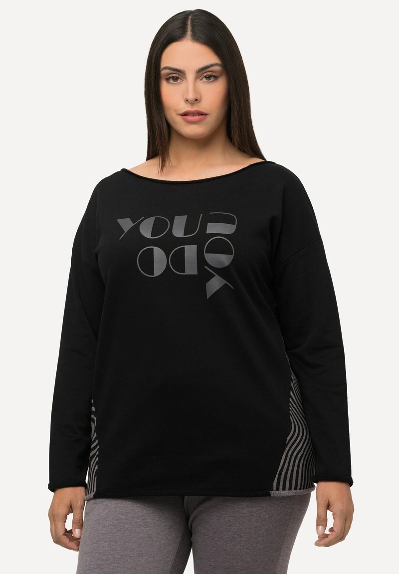 T-shirt nera a maniche lunghe con scollatura larga, caratterizzata da una grande stampa di testo grafico e accenti a pannelli laterali a righe. Tessuto morbido e confortevole.
