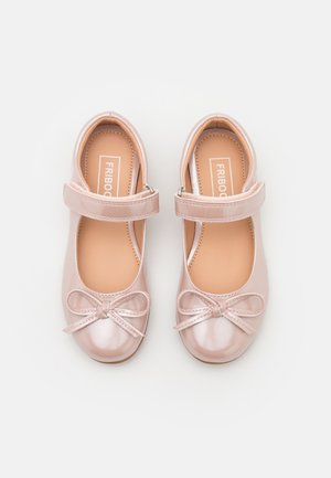 Paire de chaussures Mary Jane roses brillantes avec détail en nœud et sangles Velcro, vues de dessus sur fond blanc.
