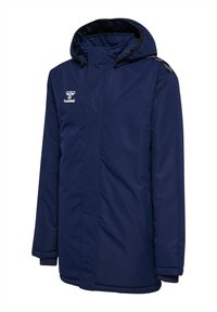 Marineblauwe geïsoleerde jas met capuchon en rits aan de voorkant, reflecterend logo op de borst en gewatteerd ontwerp voor bescherming tegen koude weersomstandigheden.