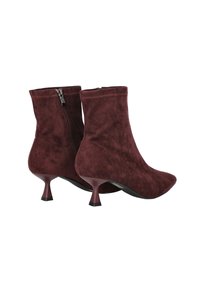 Botines de ante burdeos con punta afilada, tacón decorativo bajo y cremallera lateral. Textura suave y diseño ajustado.