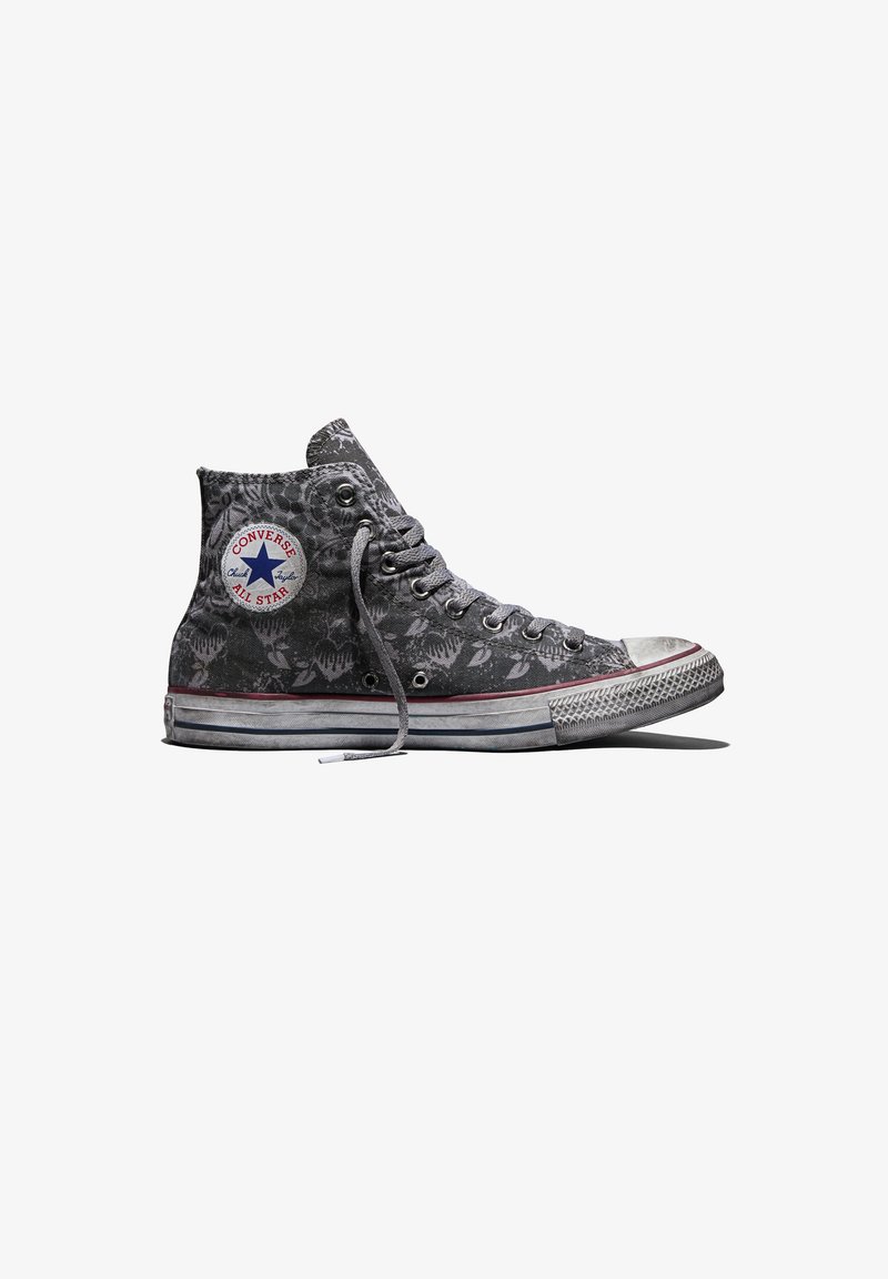 Sneaker alta grigia Converse All Star con motivo floreale, suola in gomma bianca e lacci parzialmente slacciati su sfondo bianco.