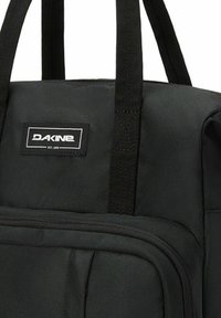 Svart Dakine toteväska med robusta handtag och en framficka med dragkedja, tillverkad av slitstarkt material.