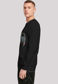 Sort sweatshirt med et farverigt grafisk design i form af en flagermus. Fremstillet af blødt materiale, har den ribbede manchetter og en klassisk pasform.